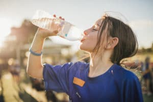 child drinking water while overheating during sports