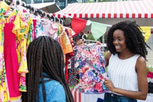 two women shopping in an outdoor retail store on a hot day