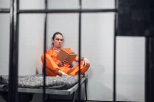prison inmate reading in a hot prison cell