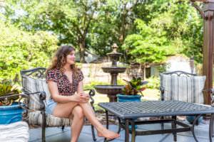 woman sitting at a backyard patio next to a water fountain