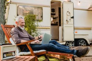 man relaxing at his rv with an evaporative cooler