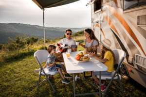 family enjoying a meal at their RV with an evaporative cooler