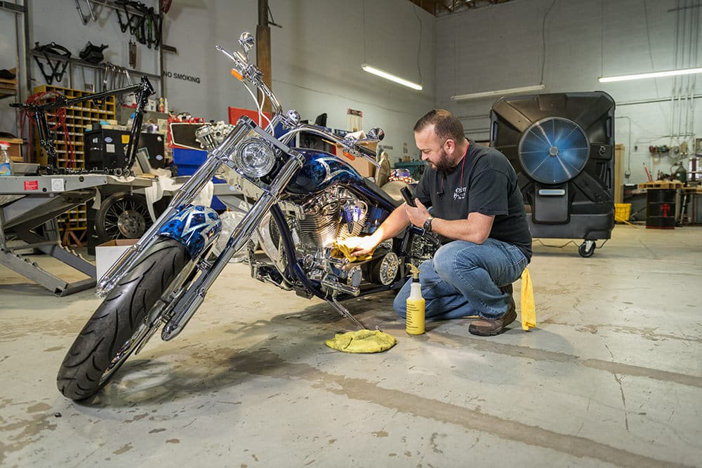 Count's Kustom garage chills with portable evap air coolers from Portacool, working on a blue chopper.