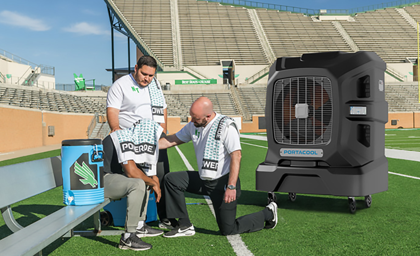 Player rests on the bench in a stadium, resting in the cooling zone from a Portacool evap cooling unit.