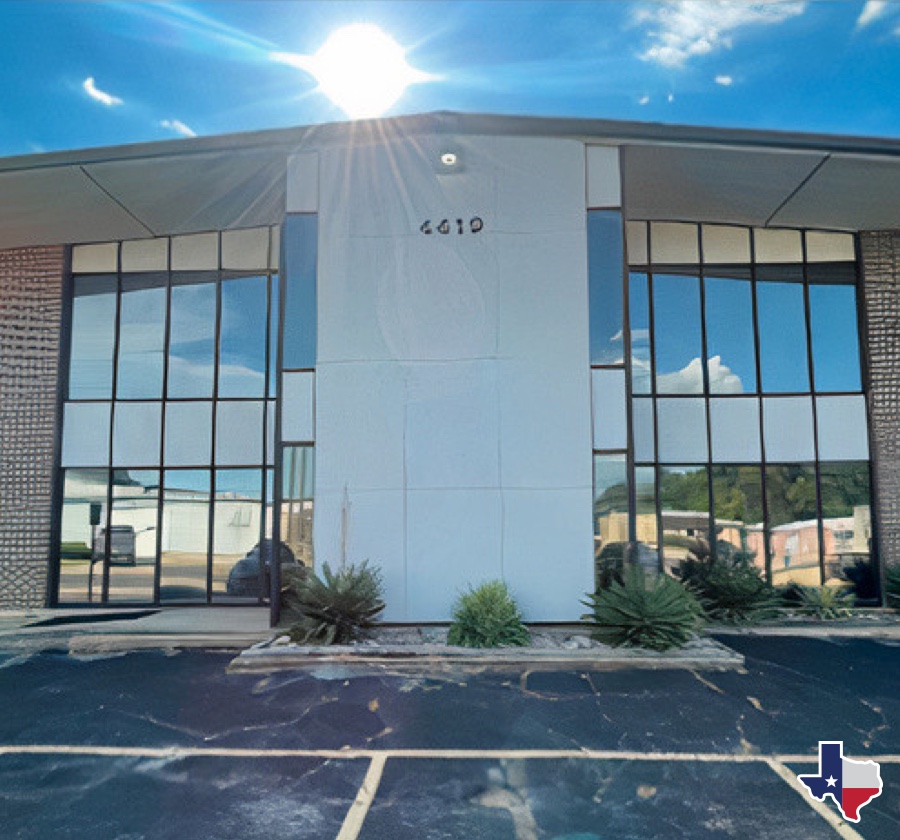 Portacool building with large windows reflecting sky, number 4619 central on facade. Bright sun above, Texas decal in corner, desert plants at entrance.